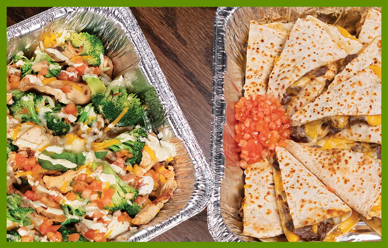 Chicken rice bowl and quesadillas in catering dishes.